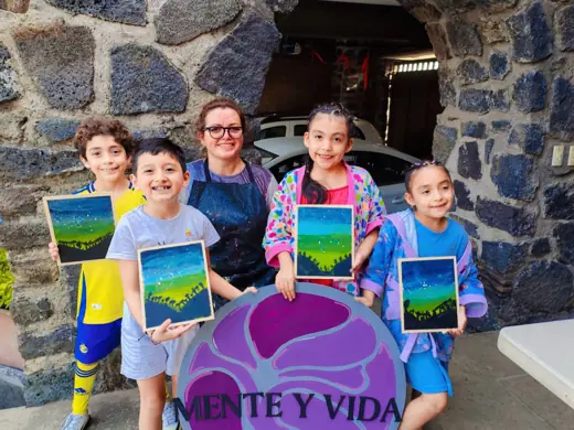 Niños mostrando pinturas en taller